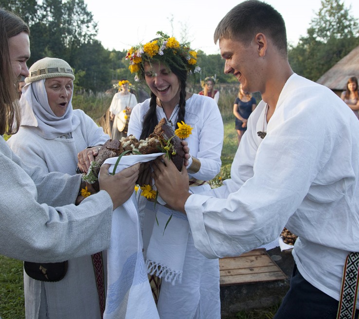 Летний лагерь (Romuvos stovykla) в Литве, ежегодно устраиваемый для молодежи общиной Ромува, исповедующей традиционную балтскую языческую веру. Женщина слева (в головном уборе и платке) – это нынешняя верховная жрица (криви) Ромува Литвы Иния Тринкуниен (Inija Trinkūnienė, родилась в 1951-м году). Иллюстрация с официального сайта общины Ромува romuva.lt.